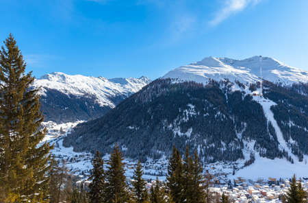 Beautiful view of Davos in Winter with snow covered roofs and the Alps, Canton of Grisons, Switzerland.の写真素材