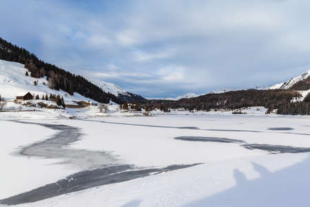 Panorama view of the frozen Davos Lake, the Davos village and the Alps in winter, Canton of Grisons, Switzerlandの写真素材