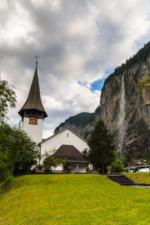 Beautiful view of  the Staubbachfall waterfall in Lauterbrunnen valley with a small chapel in foreground, Canton of Bern, Switzerlandの写真素材