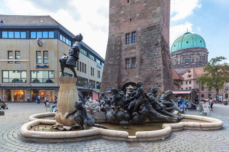 Nuremberg, Germany - September 2, 2016 - View of the Ehekarussell (Ehebrunnen, marriage) fountain in front of the Weiss Turm tower and  St. Elisabeth church in the old town of Nuremberg, Bavaria, Germanyのeditorial素材
