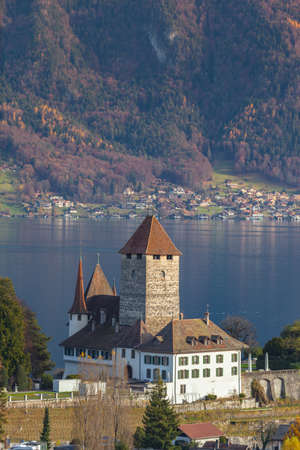 Idyllic view of Spiez town in autumn with the castle on the side of the lake Thun and the Alps in background, on Bernese Oberland, Canton of Bern, Switzerland.のeditorial素材