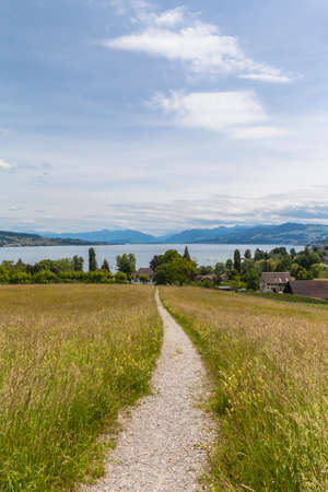 Beautiful view of Zurich lake and the alps on the hill of the peninsula Au, located in the lake Zurich at the municipality Au between Wadenswil and Horgen in the Canton of Zurich, Switzerland.の写真素材