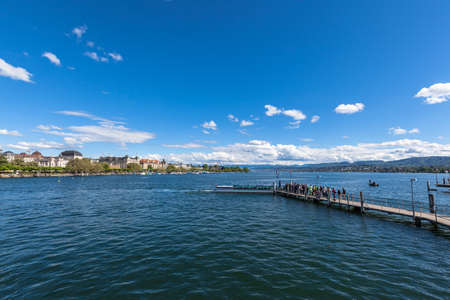 Panorama view of the Zurichsee (Zurich lake) and the cityscape of old town with Swiss Alps mountain range and blue sky cloud in background on a sunny summer day, Zurich, Switzerlandの写真素材