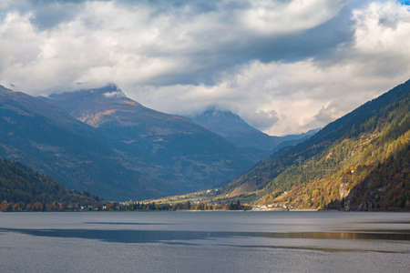 Panorama view of Poschiavo lake and Swiss Alps on the way of sightseeing train of Bernina Express on cloudy autumn day, Canton of Grisons, Switzerlandの写真素材