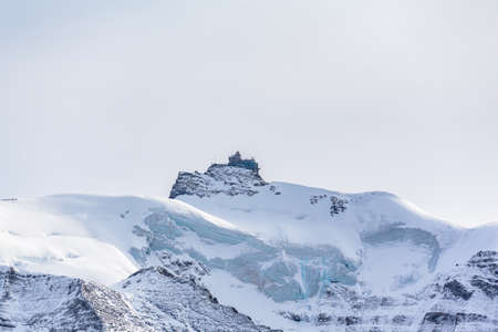Stunning view of famous Sphinx Observatory, and Jungfraujoch railway station located on Bernese Oberland between Jungfrau and Monch, with glacier and snow on cloudy autumn day, Canton of Bern, Switzerlandの写真素材
