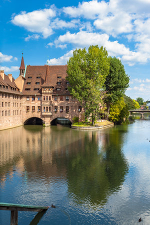 Beautiful view of the Heilig-Geist-Spital, a historical hospital on the Pegnitz river in the old town of Nuremberg, Bavaria, Germanyの写真素材
