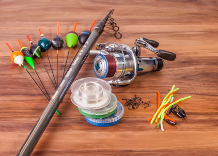 fishing pole with rings and reel, floats lie on American walnut boards