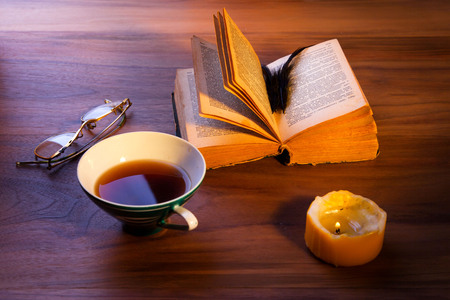 An open book on the table. A gloomy burning candle.の写真素材