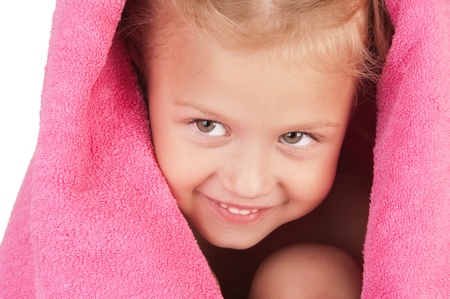 Smiling little girl wrapped in a pink towel close-upの写真素材