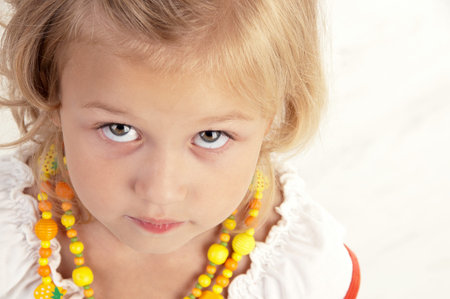 Cute little girl posing  for the camera and looking up  close-up
