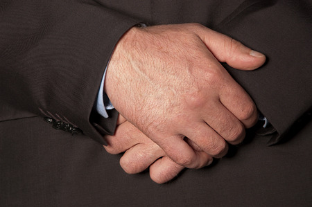 Man in suit folded his hands in front of him closeupの写真素材