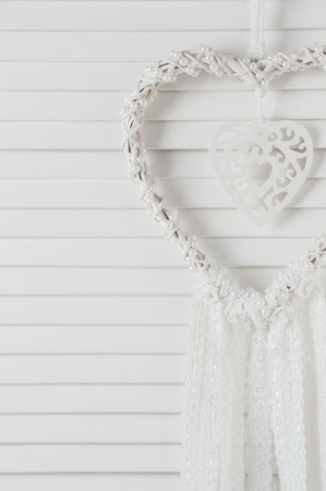 White heart dream catcher with white lace in bedroom interior close up. Wedding decorの写真素材