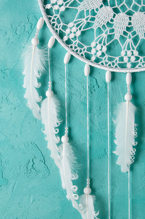 White dream catcher on turquoise textured background. Texture of concrete.の写真素材