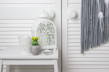 White candlesticks and gray dream catcher in bedroom interior on door background. Bedroom decorの写真素材