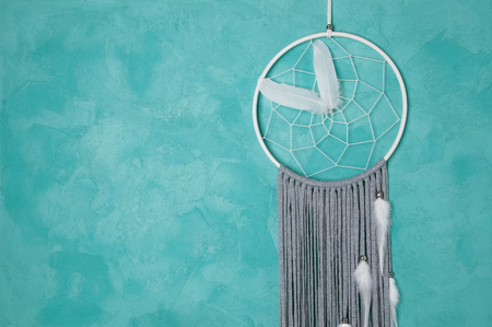 White gray dream catcher on turquoise textured background. Texture of concrete.の写真素材