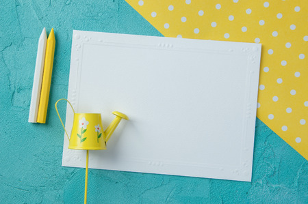 Yellow white polka dot texture, blank note and wax pencils on aquamarine textured background.Top view and copy space for textの写真素材