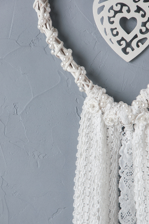 White heart lace dream catcher on gray textured background. Texture of plaster, copy space for textの写真素材