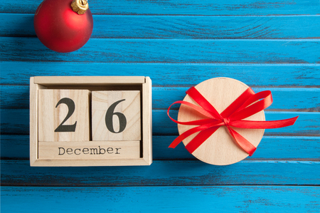 Boxing day sale , wooden calendar and gift box with red bow on blue shabby wooden backgroundの写真素材