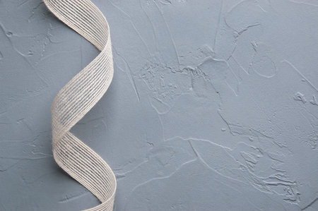 Linen ribbon on gray textured  background. Copy space for text