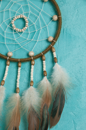 Olive dream catcher close up on aquamarine  textured background. Texture of concreteの写真素材