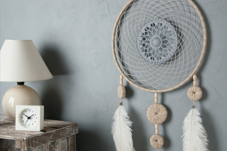 Gray beige dream catcher in bedroom interior on gray textured background. Bedroom decorの写真素材