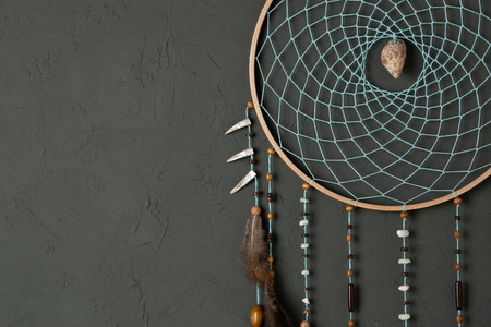 Turquoise dream catcher close up on gray textured background. Copy spzce for text.の写真素材