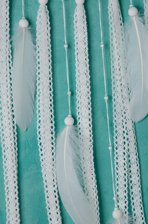 White draem catcher close up on aquamarine textured background.の写真素材