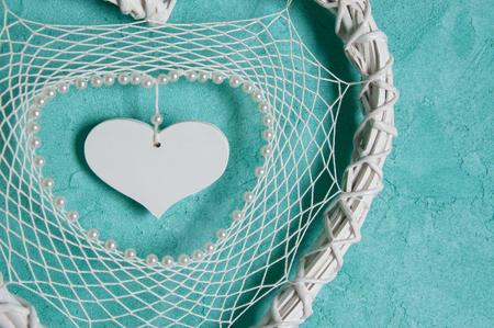 White heart lace dream catcher close up on aquamarine textured background. Texture of concrete, copy space for textの写真素材