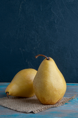 Two yellow pears on shabby wooden blue backgroundの写真素材