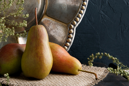 Pears and vintage plate on black backgroundの写真素材