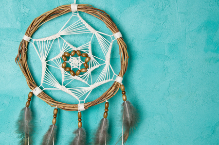 Brown cream dream catcher on aquamarine textured background. Copy space for text.の写真素材