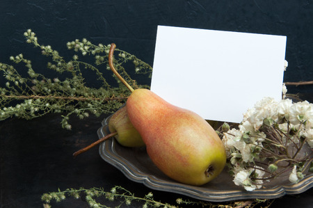 Two pears and vintage plate on black background.Copy space for text.の写真素材