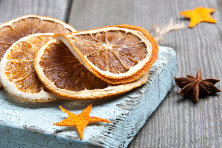 Dried orange on blue board on old wooden background. Copy space for text.の写真素材