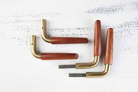 Two pare of vintage wooden brass door handles on shabby white wooden background. Copy space for...