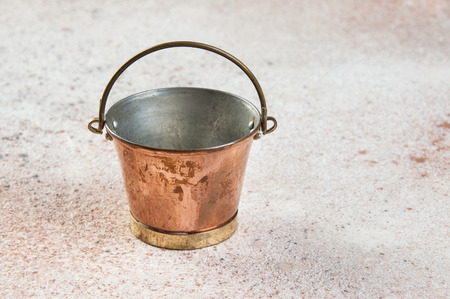 Vintage copper bucket on concrete background. Copy space for text.の写真素材