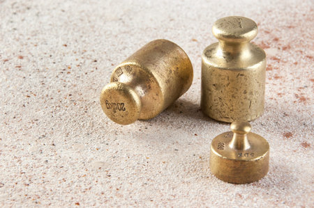Antique bronze weights for scales on concrete background. Copy space for text.