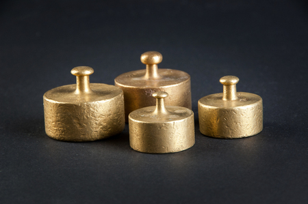 Four vintage bronze weights on black background. Copy space for text.の写真素材