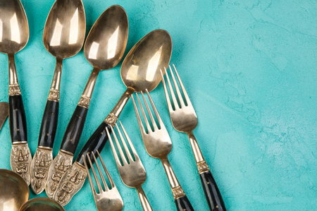 Brass spoons and forks on concrete background. Copy space for text.の写真素材