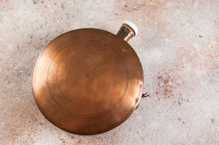 Antique copper flask on concrete background. Copy space for text.の写真素材
