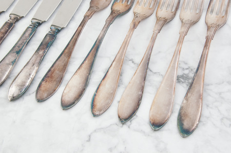 Vintage knives and forks close up on white gray background. Copy space for text.の写真素材