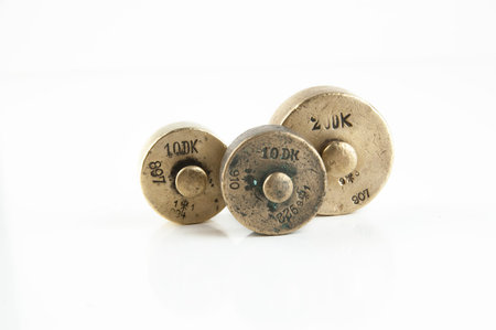Antique bronze weights for scales on white background. Kitchen decor, food photography props.