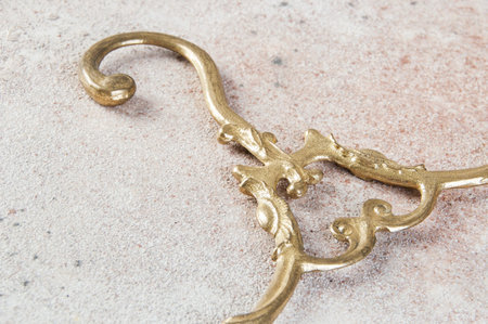Antique brass clothes hanger on concrete background. Copy space for text, photography props.