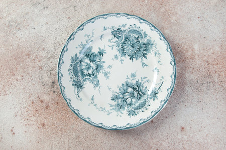 Antique porcelain plate on concrete background. Copy space for text, food photography props.
