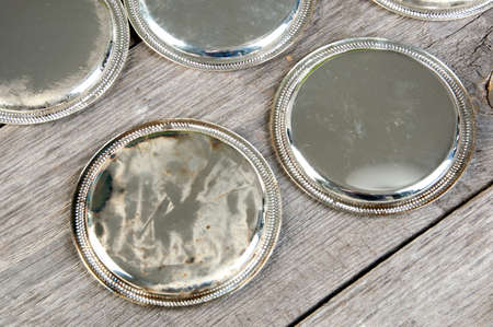 Antique silverplated coasters on wooden background. Copy space for text.の写真素材