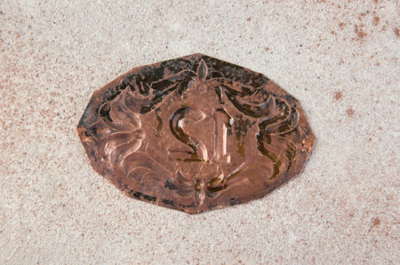 Antique copper door number on concrete background. Copy space for text.