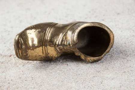 Old brass ashtray in the shape of a shoe on concrete
background. Photography props.の写真素材