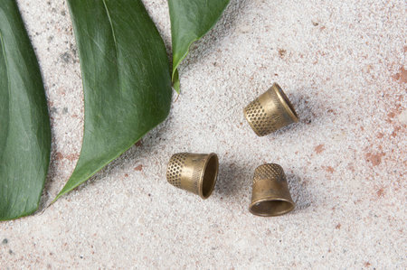 Antique brass thimbles on concrete background. Copy space for text.