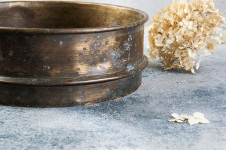 Antique brass  sieve on concrete background. Copy space for text.の写真素材