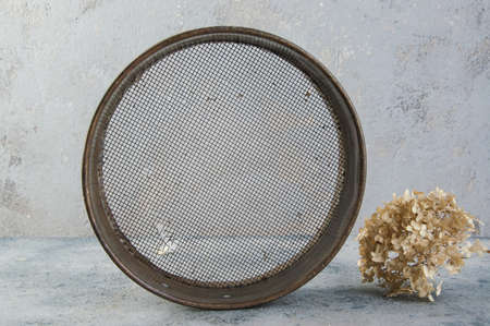 Antique brass  sieve on concrete background. Copy space for text.の写真素材