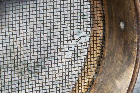 Antique brass  sieve on concrete background. Copy space for text.の写真素材